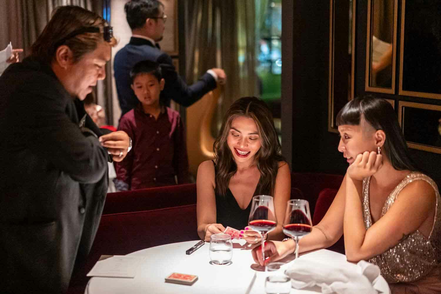 magician performing for two ladies at madame fan singapore